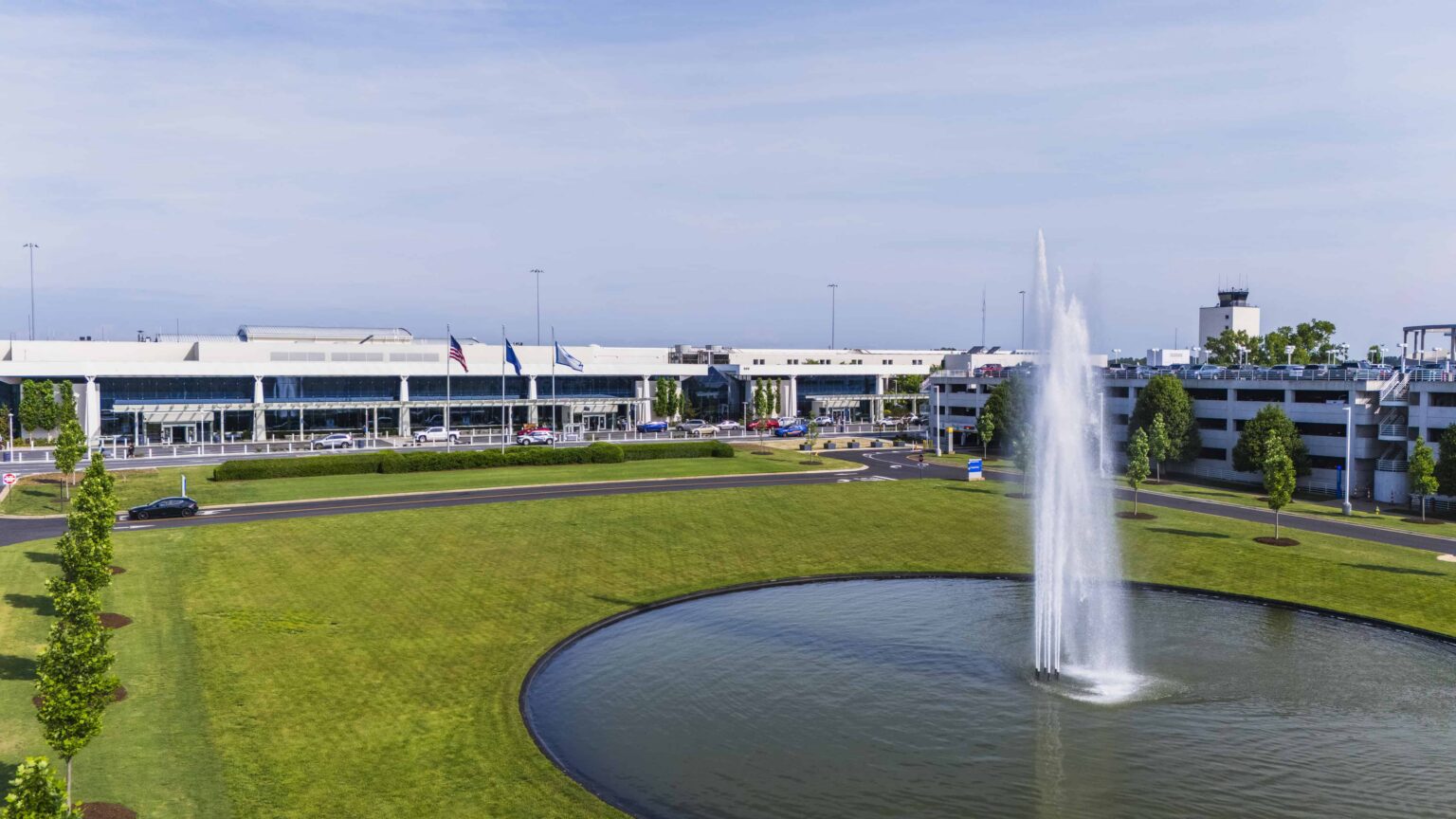The GSP terminal building seen across its green front lawn with the water fountain in the foreground